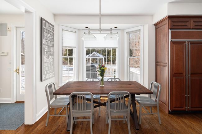 Dining space with dark hardwood finished floors, large windows and door out to oversized deck | Image 13