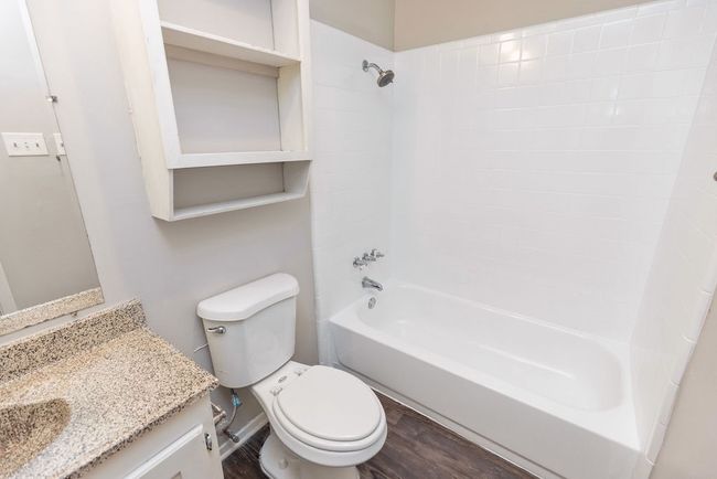 Full bath featuring shower / tub combination, wood finished floors, toilet, and vanity | Image 17