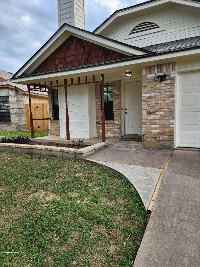 View of front of property with brick siding, covered porch, a chimney, and a front yard | Image 7