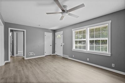 Foyer featuring ceiling fan and light and newly installed vinyl plank flooring | Image 2