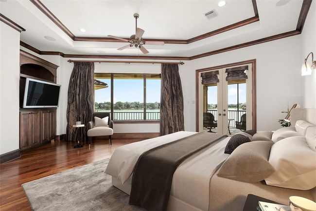 Primary bedroom suite is a spacious and luxurious retreat, bathed in natural light from the broad windows that provide panoramic views of Taylor Lake. Virtually staged. | Image 31