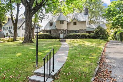 View of front of home with verdant lawn & perennial plantings. | Image 1