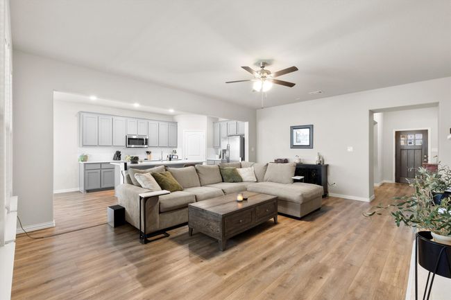 Living area featuring ceiling fan and light wood-style floors | Image 7