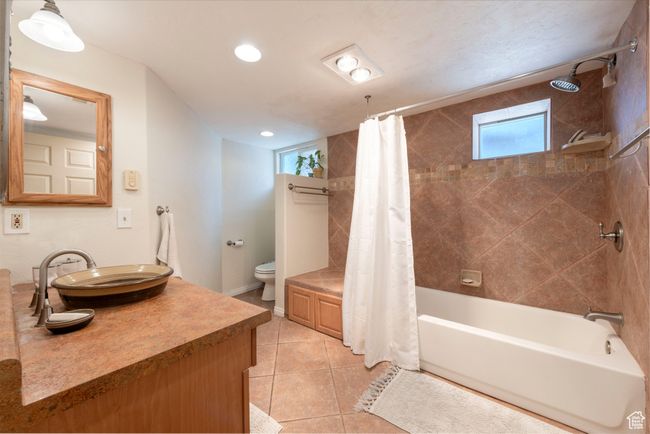 Full bathroom with plenty of natural light, vanity, shower / tub combo, tile patterned floors, and recessed lighting | Image 21