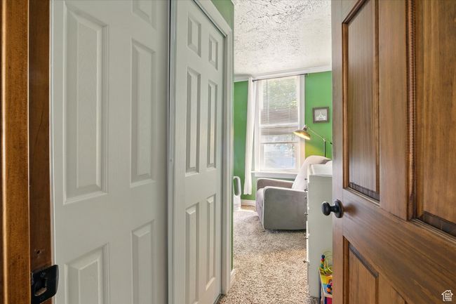 Hallway featuring a textured ceiling and carpet flooring | Image 11