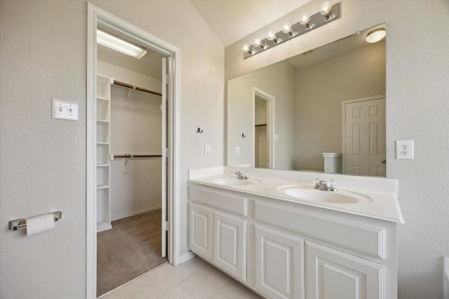 Full bathroom featuring double vanity, tile patterned floors, and a walk in closet | Image 9