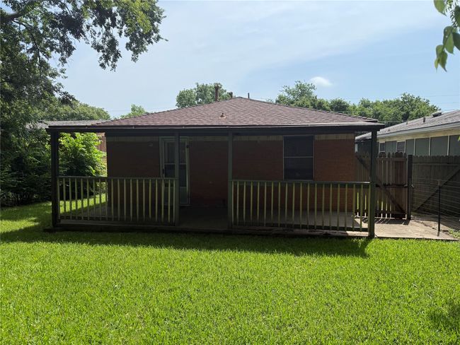 Rear view of house featuring a shingled roof and brick siding | Image 25