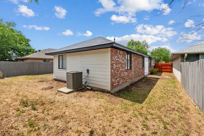View of side of property with a fenced backyard, brick siding, a yard | Image 32