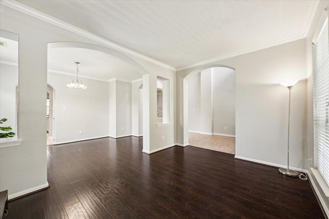 Looking from the den towards the dining room and entry hallway. | Image 11
