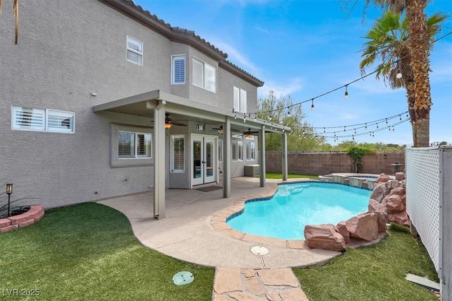 View of pool with a fenced backyard, a ceiling fan, a pool with connected hot tub, and a patio area | Image 41