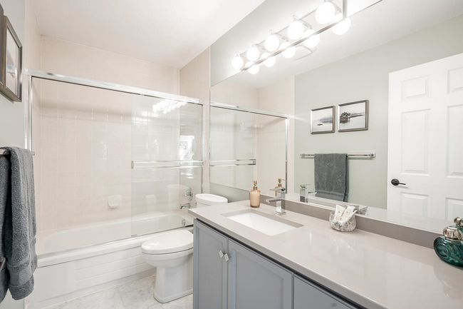 Bathroom with enclosed tub / shower combo, toilet, and vanity | Image 23