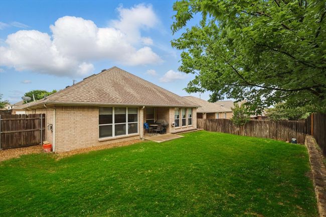Back of house featuring a patio, a fenced backyard, brick siding, a shingled roof, and a yard | Image 38