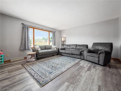 Living room featuring wood-type flooring and a baseboard radiator | Image 2