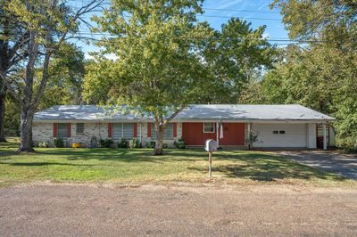 Ranch-style house featuring a garage and a front lawn | Image 1