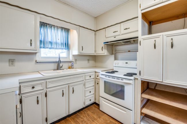 Kitchen featuring sink, white electric stove, and white cabinets | Image 15