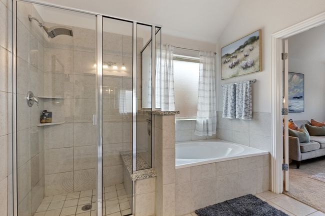Full bathroom featuring lofted ceiling, tile patterned floors, a garden tub, and a shower stall | Image 19