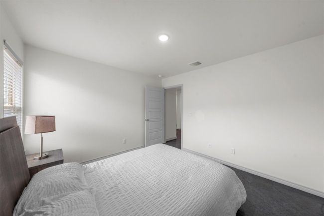 Bedroom with baseboards, visible vents, and dark carpet | Image 16