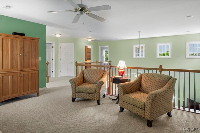 Sitting room featuring light carpet, ceiling fan, and plenty of natural light | Image 32