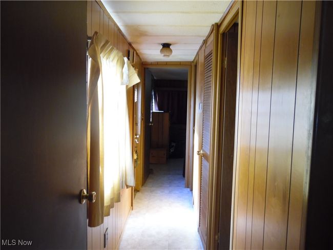 Hall featuring wood walls | Image 7