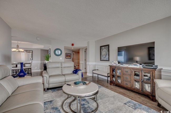 Living room featuring a notable chandelier, a textured ceiling, and hardwood / wood-style floors | Image 5