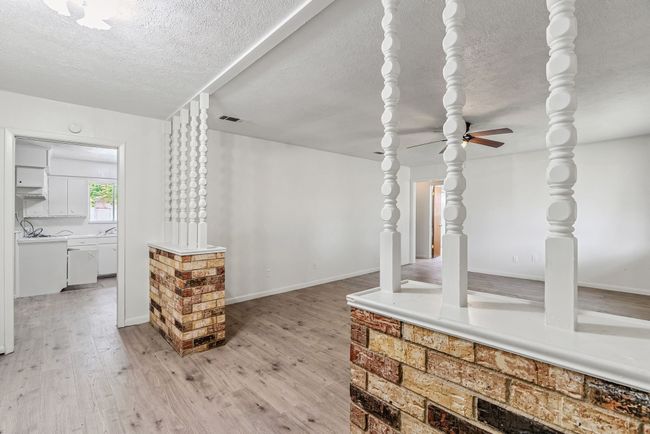 Unfurnished living room featuring a textured ceiling, light wood-type flooring, and a ceiling fan | Image 7