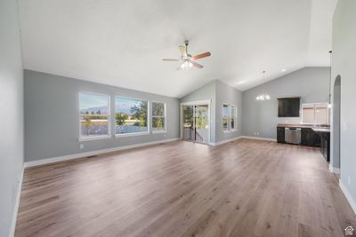 Living & dining rooms with ceiling fan, vaulted ceiling, and LVP wood-style flooring | Image 3