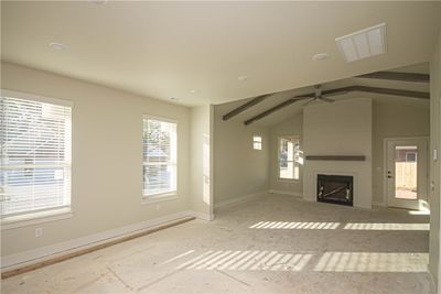 Large windows flood the living room with natural light, creating a warm and welcoming atmosphere. | Image 3