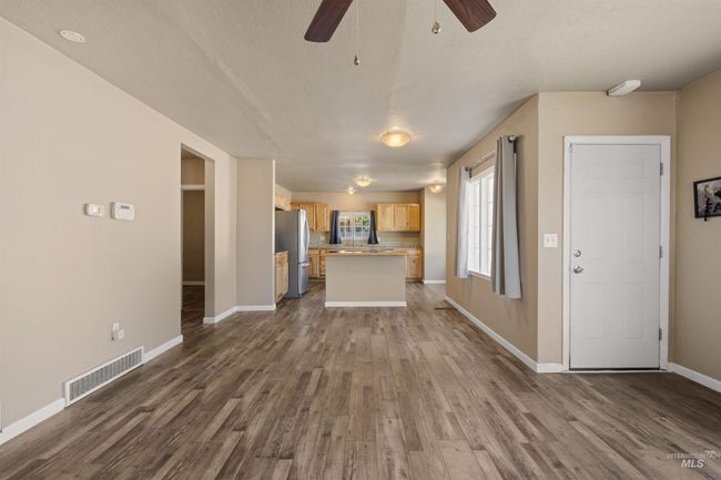 Unfurnished living room with dark wood-style floors, ceiling fan, and a textured ceiling | Image 8