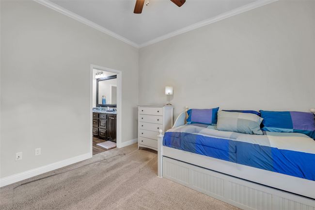 Bedroom featuring crown molding, light colored carpet, baseboards, connected bathroom, and ceiling fan | Image 28