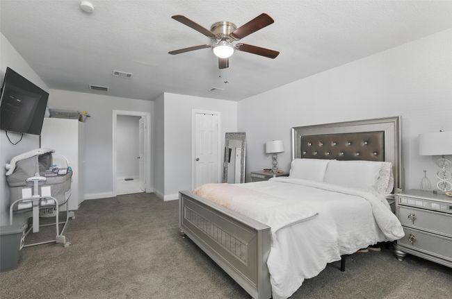 Carpeted bedroom featuring a ceiling fan and baseboards | Image 26