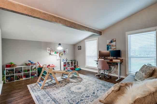 Recreation room featuring dark wood-style flooring, baseboards, and vaulted ceiling with beams | Image 12
