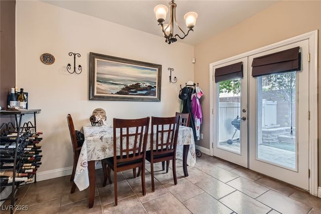 Dining area with French doors leading out to the rear patio and an inviting chandelier | Image 9