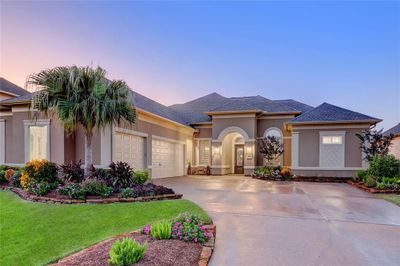 Beautiful meditteranean design flanked by stunning landscaping. An added bonus is the three car garage. | Image 1