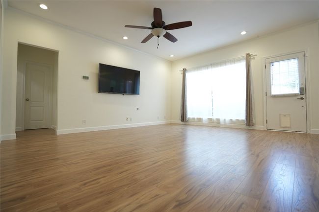 Family room with light wood-style flooring, ceiling fan, ornamental molding, and recessed lighting | Image 6