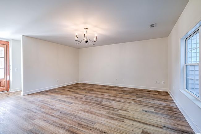 Unfurnished room with a chandelier and wood finished floors | Image 29
