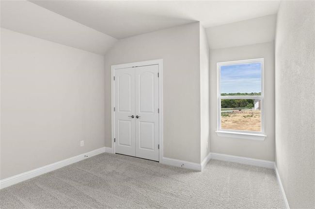 Unfurnished bedroom featuring carpet floors, baseboards, lofted ceiling, and a closet | Image 19