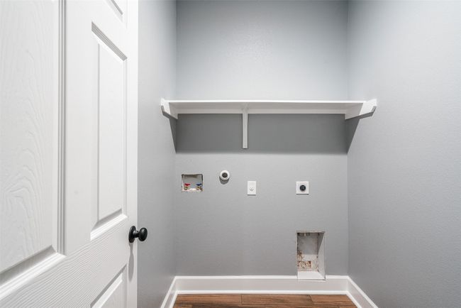 Laundry room with electric dryer hookup, gas dryer hookup, washer hookup, wood finished floors, and baseboards | Image 25