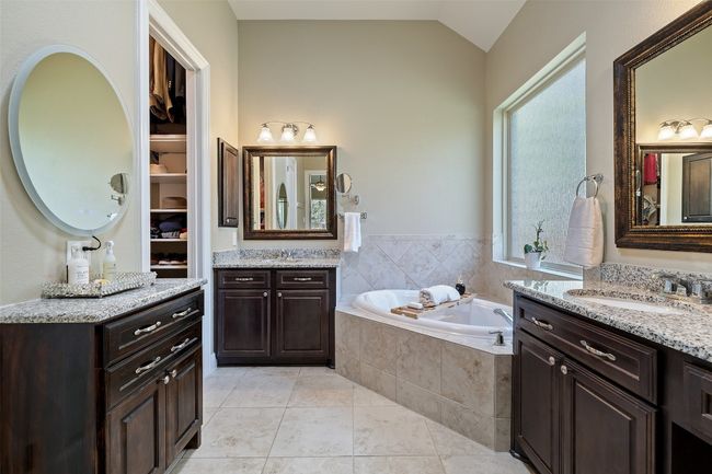 Spa like bathroom with dual vanities, granite countertops, soaking tub, separate walk in shower, a tubular skylight, and a separate vanity space | Image 18