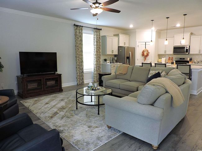 Living room with ceiling fan, ornamental molding, wood finished floors, baseboards, and recessed lighting | Image 12