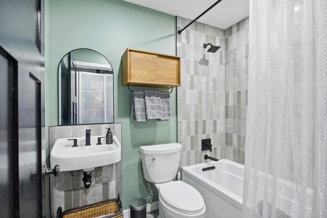 Bathroom with toilet and shower / bath combination with curtain | Image 26