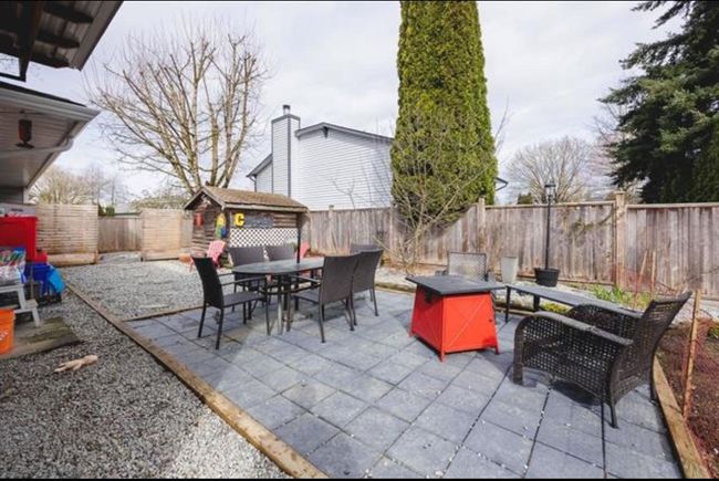 Fenced backyard with outdoor dining space, a patio, and a storage shed | Image 17