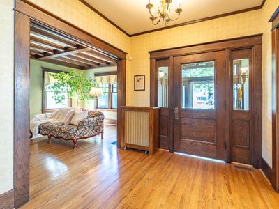 The grand entrance opens to a light filled layout where rich hardwood floors stretch endlessly from room to room. | Image 2