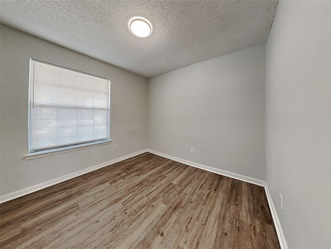 Spare room featuring a textured ceiling and wood finished floors | Image 12