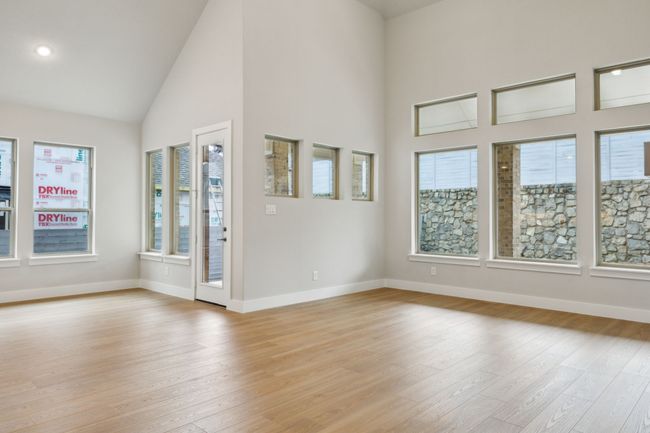 Spare room featuring light wood-style flooring, healthy amount of natural light, high vaulted ceiling, and recessed lighting | Image 14