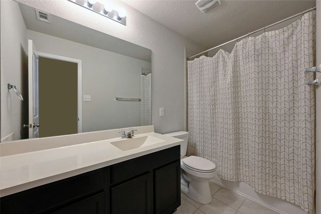 Bathroom featuring tile patterned floors, vanity, and a textured ceiling | Image 6