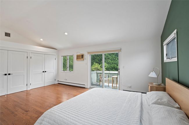 Laundry area featuring stacked washer / drying machine and light wood-style floors | Image 24