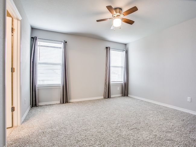 Carpeted empty room with a ceiling fan and baseboards | Image 14