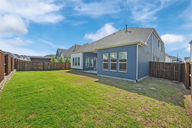Back of property featuring a lawn, a fenced backyard, brick siding, and roof with shingles | Image 40