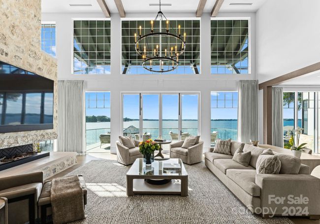 Two story Grand Salon featuring exposed wood beams & a window expanse that frames long range water views with fold away doors that lead to the terrace. | Image 4