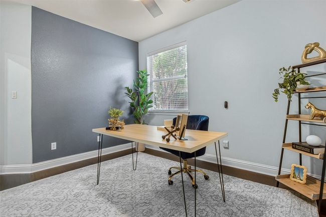 Office space with wood finished floors, baseboards, and ceiling fan | Image 25
